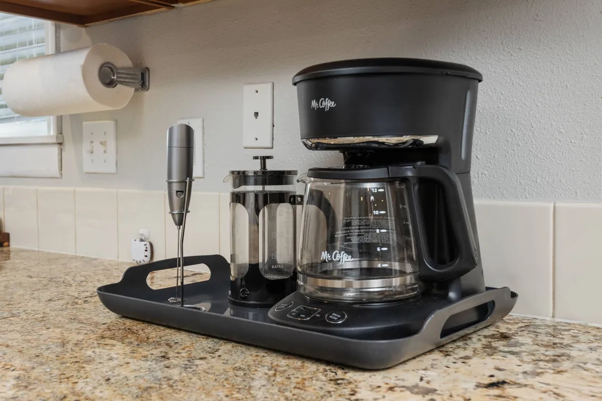 A cozy coffee station with a coffee maker, French press, and milk frother, inviting guests to enjoy morning rituals or mid-day breaks that blend productivity with comfort.